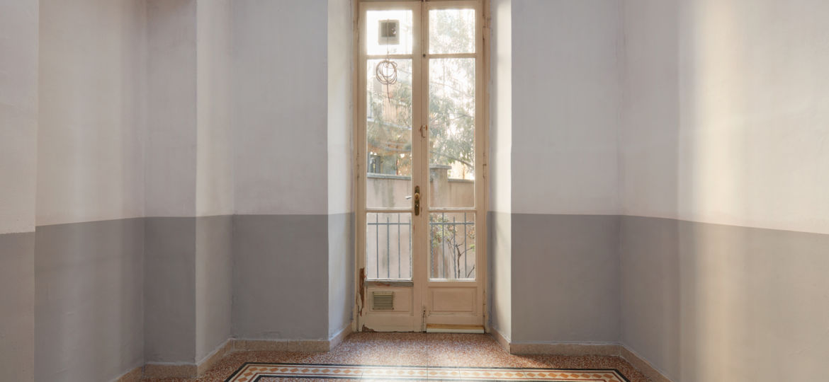 Empty room interior with tiled floor and window with balcony